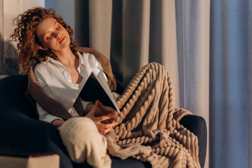 Cozy lifestyle aesthetic shown through a quiet reading moment with a soft blanket.