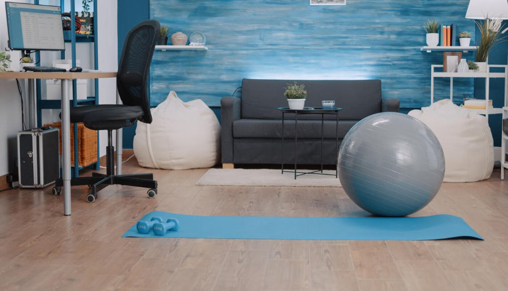 Multi-purpose living space with a home office, workout area, and lounge setup in one room.
