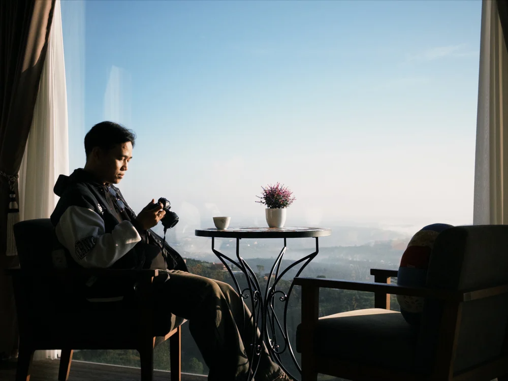Soft travel vacation planning shown through a quiet morning with coffee, a camera, and a scenic view.