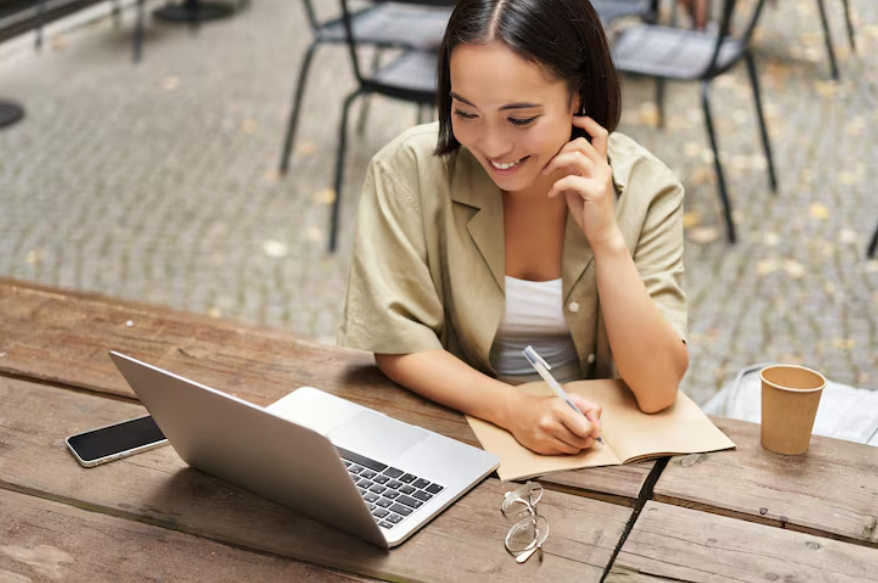 Why personality quizzes are popular shown through a woman taking notes beside a laptop.