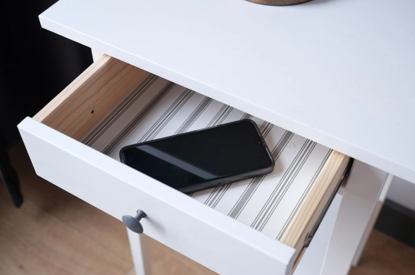 Phone boundaries shown through a smartphone placed inside a drawer to reduce distractions.